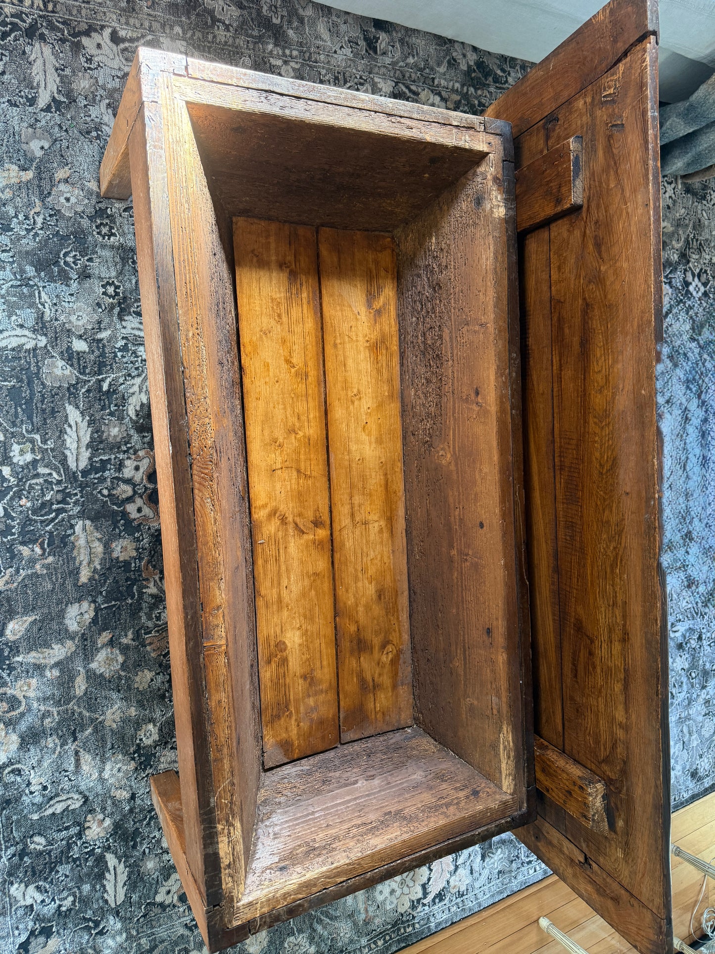 The French antique dough table converted to a coffee table for modern day use shows the lid lifted off to expose the storage space within the coffee table