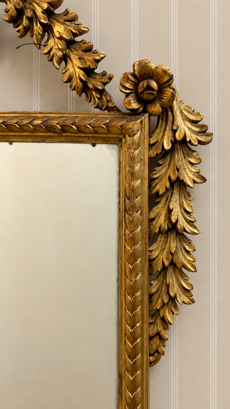 Italian giltwood mirror with urn crest, carved foliage and scroll feet  Close up of rosette 