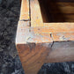 The antique French coffee table converted from a dough table shows the patina of the pine construction