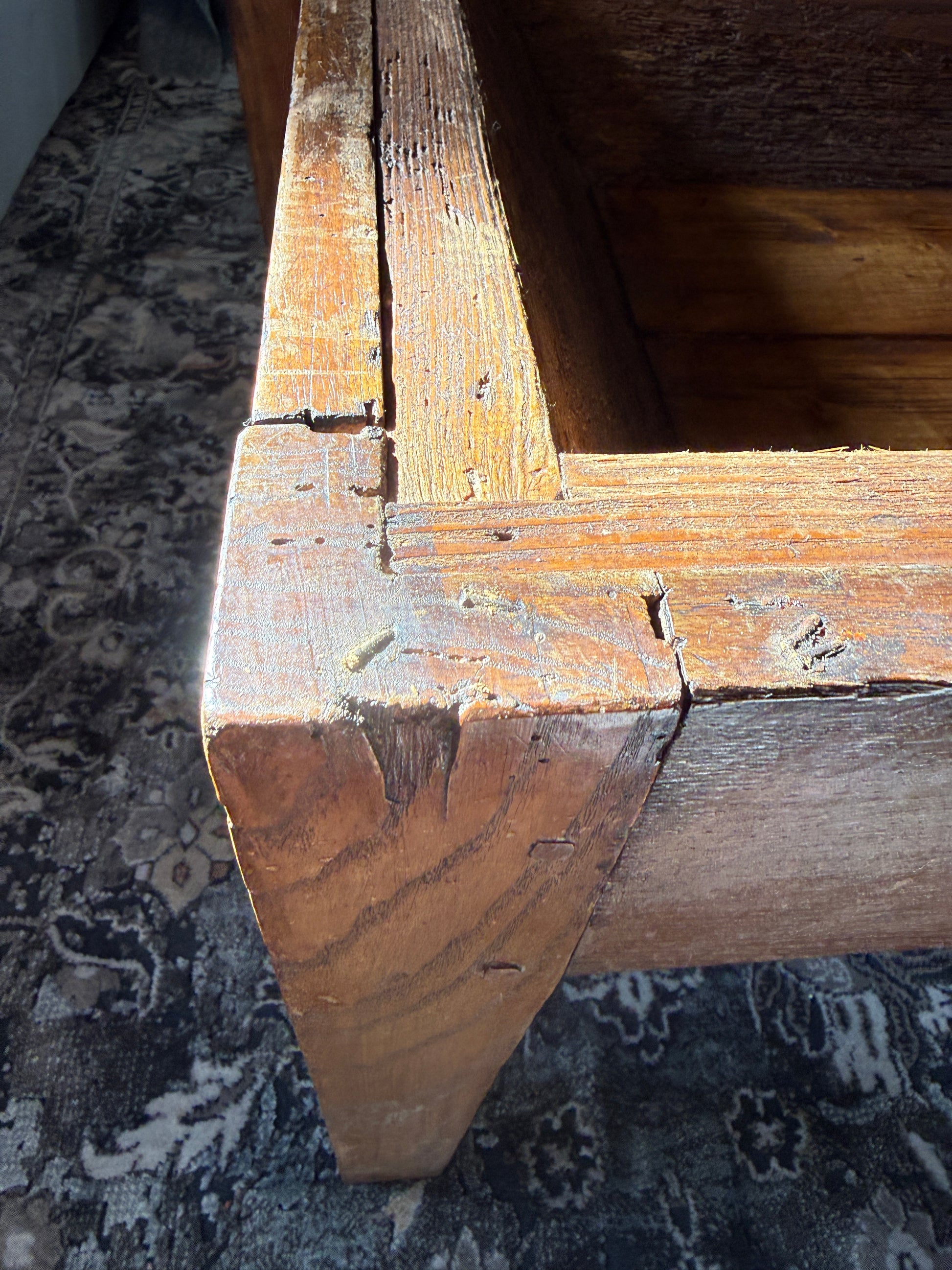 The antique French coffee table converted from a dough table shows the patina of the pine construction