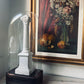 Decorative white column sculpture under a glass dome with a painting of fruits and flowers in the background.  Antique French Rectangular Glass Dome | Napoleon III Period