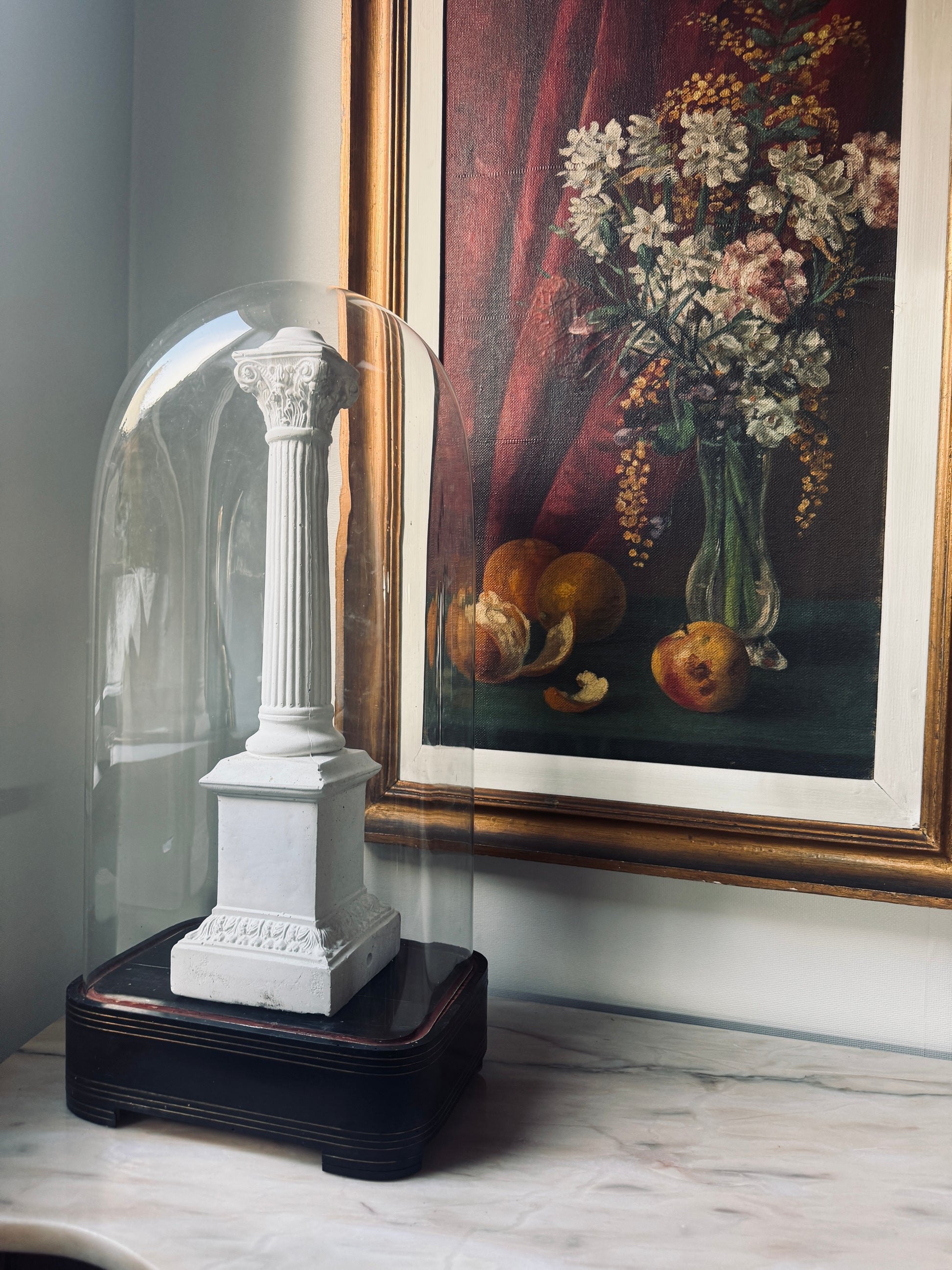 Decorative white column sculpture under a glass dome with a painting of fruits and flowers in the background.  Antique French Rectangular Glass Dome | Napoleon III Period