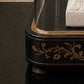Decorative black and gold piece of furniture with intricate designs on a dark surface. dome on a wooden surface. Antique French glass dome large oval