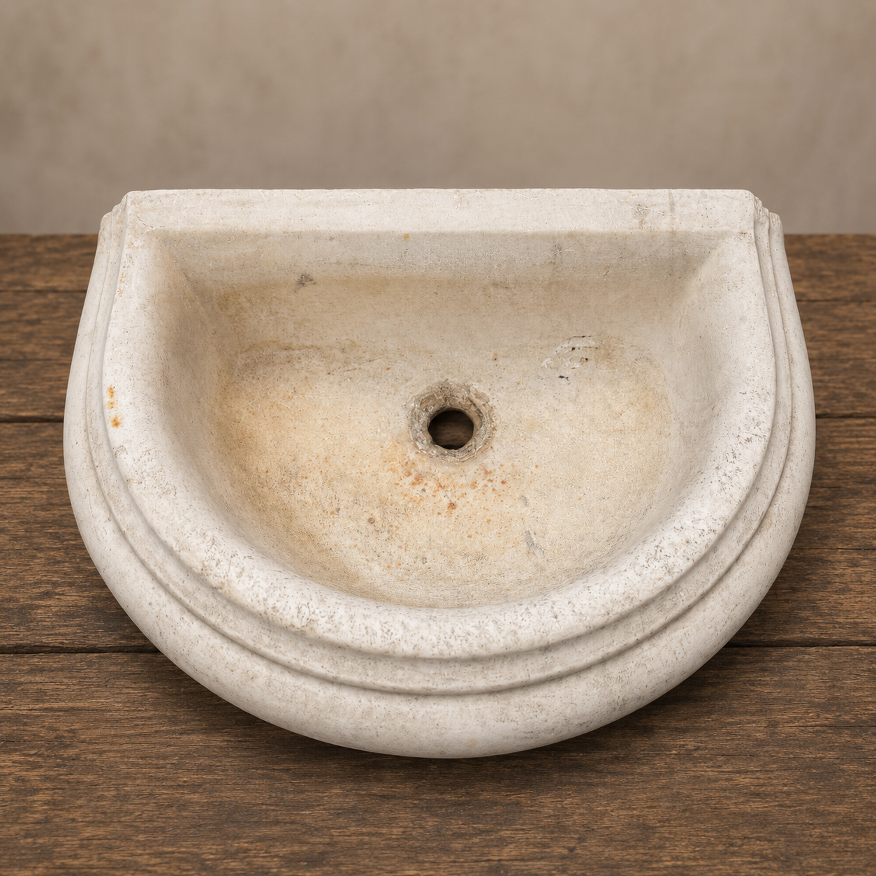 Stone sink on a wooden surface with a neutral background antique french