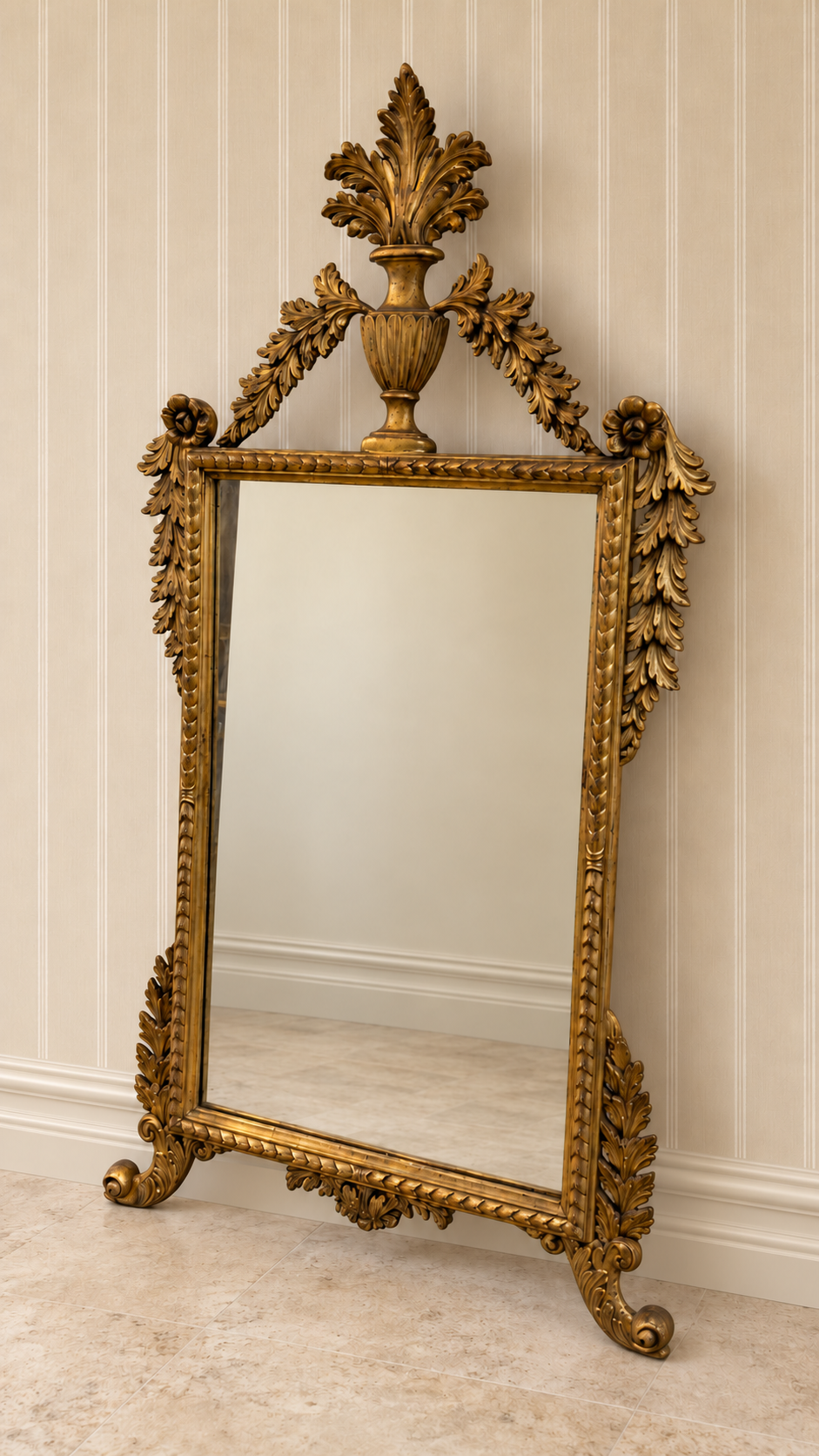 Italian giltwood mirror with urn crest, carved foliage and scroll feet