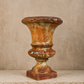 Rusticated urn with a textured surface on a neutral background. French antique. 