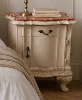 Vintage-style nightstand with marble top and candle holder in a bedroom setting. Italian marble bedside tables with red marble.  
