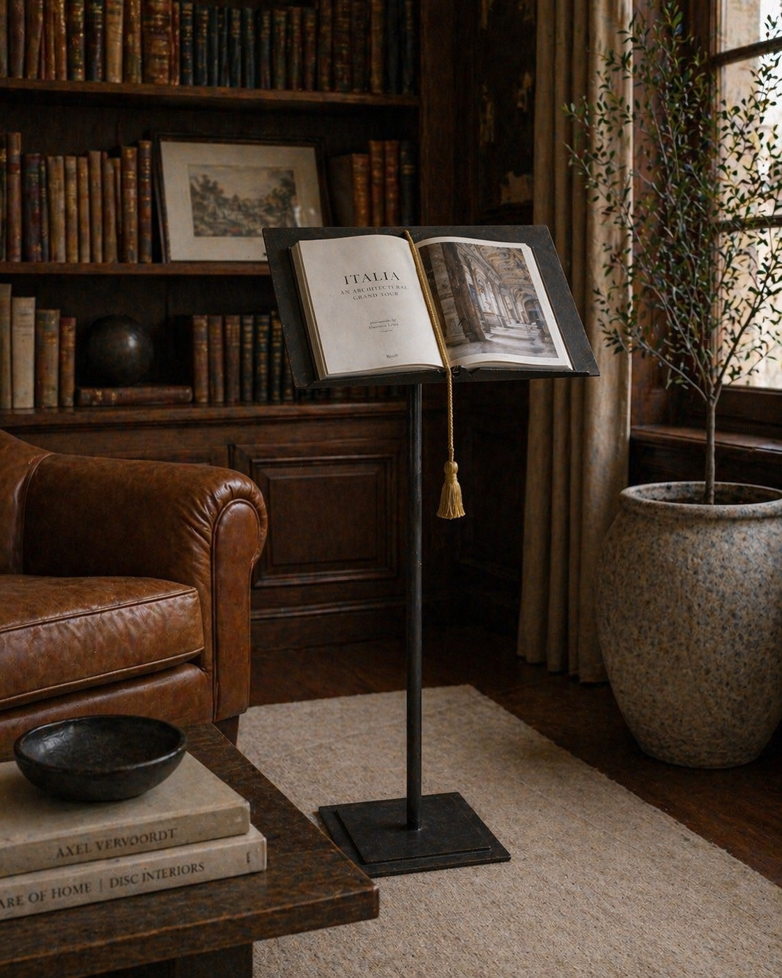 Open book on a forged Italian iron antique lectern  in a cozy room with books and a plant